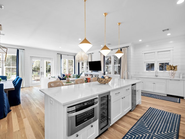 kitchen featuring beverage cooler, open floor plan, and french doors