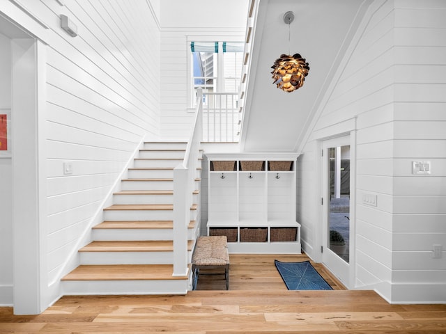 staircase with vaulted ceiling and wood finished floors