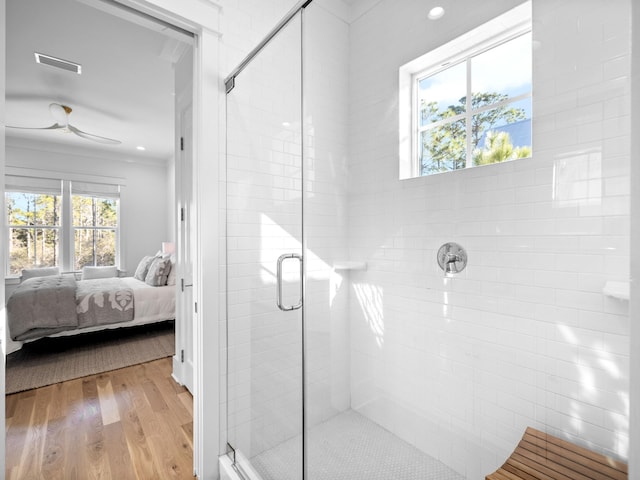 full bathroom with a stall shower, visible vents, wood finished floors, and ensuite bath