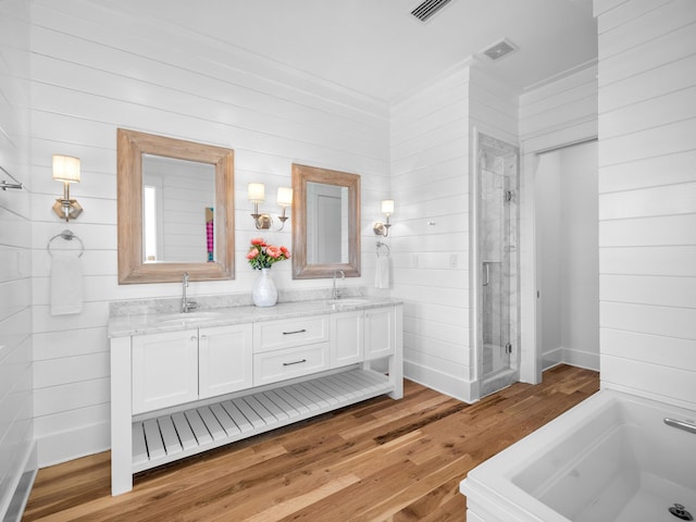 full bath featuring double vanity, visible vents, a stall shower, and a sink