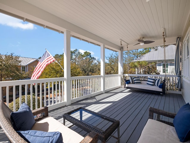 wooden deck with an outdoor living space and a ceiling fan