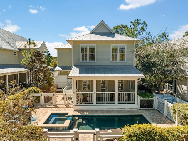 rear view of property with a standing seam roof, a gate, fence, metal roof, and a patio area