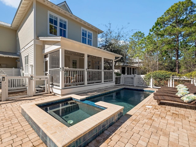 back of house featuring a patio, fence, an in ground hot tub, and a sunroom