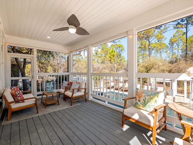 sunroom / solarium featuring a healthy amount of sunlight, wood ceiling, and ceiling fan