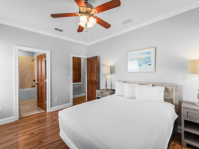 bedroom with ornamental molding, wood finished floors, visible vents, and baseboards