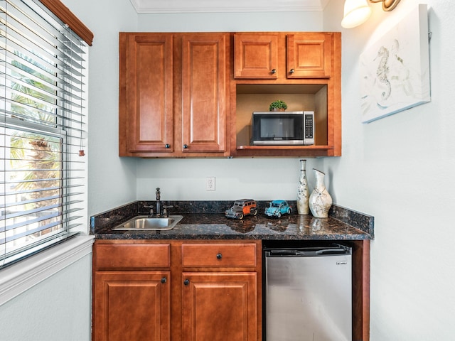 kitchen featuring fridge, stainless steel microwave, a wealth of natural light, and a sink