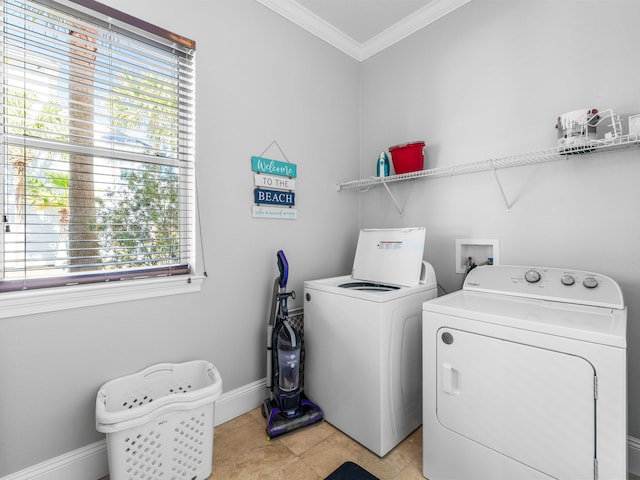 laundry area featuring ornamental molding, washing machine and dryer, laundry area, and a healthy amount of sunlight