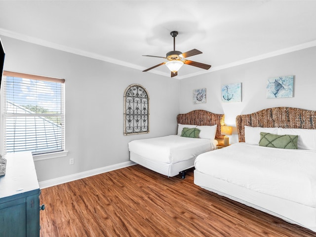 bedroom featuring baseboards, wood finished floors, a ceiling fan, and crown molding