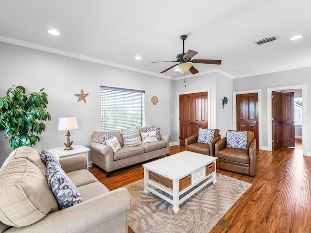 living area with visible vents, plenty of natural light, and wood finished floors