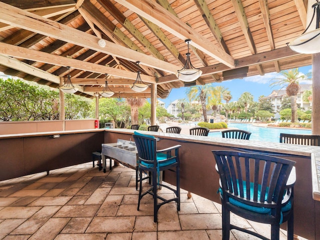 view of patio / terrace featuring a community pool and outdoor dry bar