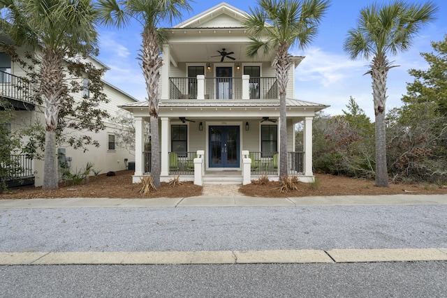 view of front of home with ceiling fan, metal roof, a porch, a balcony, and a standing seam roof