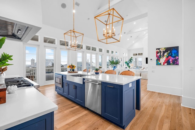 kitchen with stainless steel appliances, blue cabinetry, light wood-type flooring, and an inviting chandelier