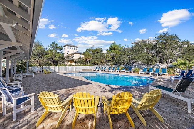 pool with a patio and fence