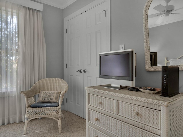 sitting room with a ceiling fan and crown molding