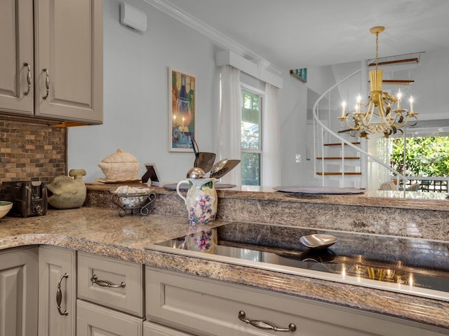 kitchen featuring decorative backsplash, black electric cooktop, crown molding, pendant lighting, and a notable chandelier