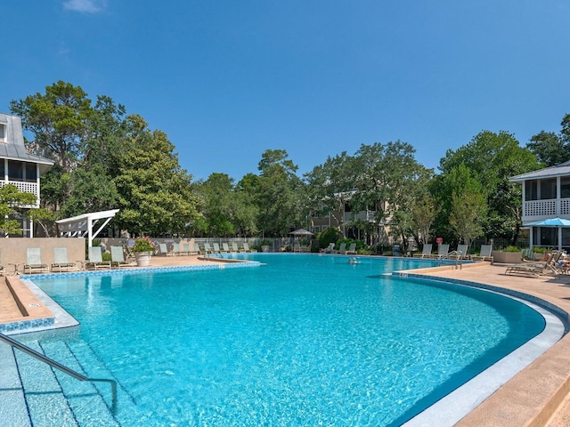 community pool with a patio and fence