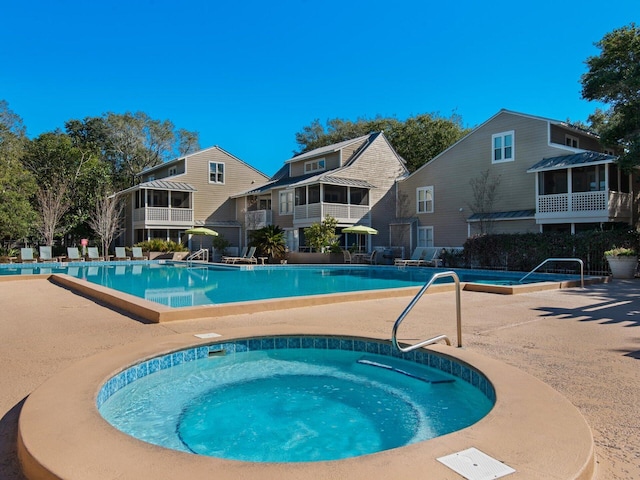 pool with a community hot tub and a patio