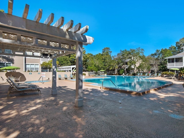 pool with a patio area and a pergola