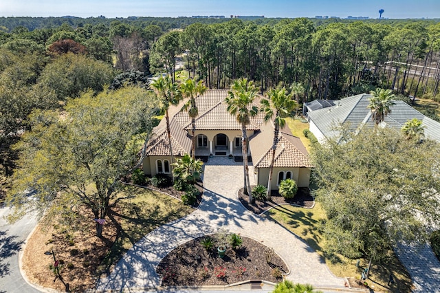 drone / aerial view with a wooded view