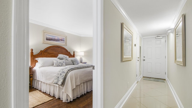 bedroom with tile patterned floors, baseboards, and ornamental molding