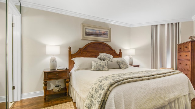 bedroom featuring wood finished floors, baseboards, and ornamental molding