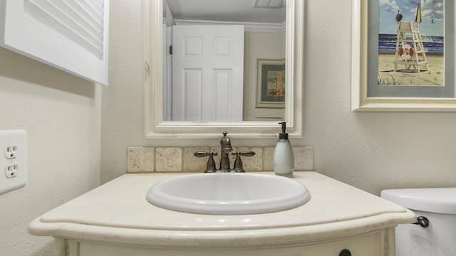 half bath with visible vents, toilet, vanity, and a textured wall