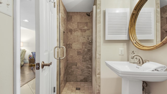 full bath with a shower stall, baseboards, and a sink