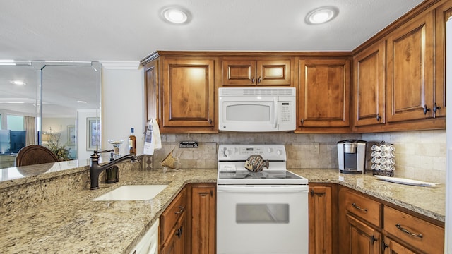 kitchen featuring a sink, white appliances, tasteful backsplash, and light stone countertops