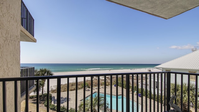 balcony featuring a view of the beach, central AC unit, and a water view