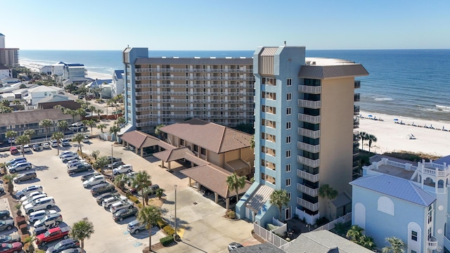 view of building exterior with uncovered parking and a water view