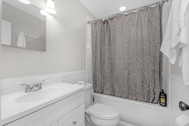 full bathroom with shower / bath combo, wainscoting, vanity, and toilet