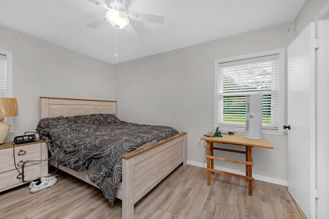 bedroom with a ceiling fan, baseboards, and wood finished floors