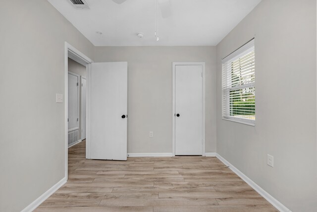 unfurnished bedroom featuring light wood-type flooring, visible vents, and baseboards