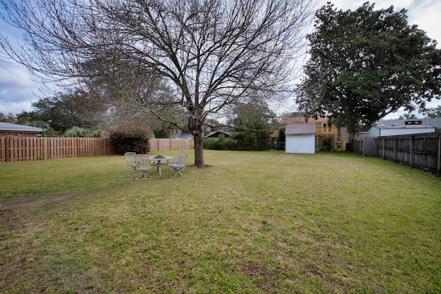 view of yard featuring a fenced backyard, an outdoor structure, and a storage unit