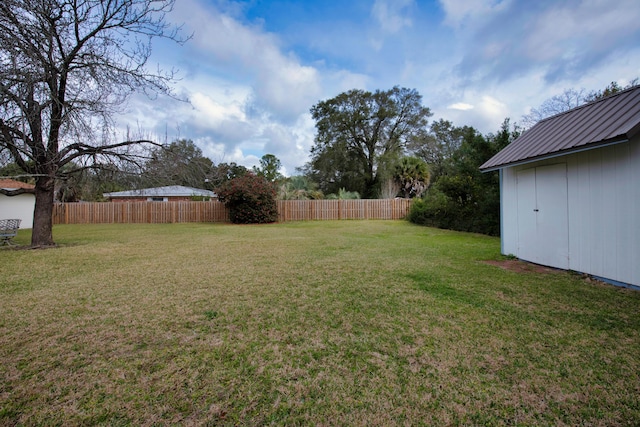 view of yard with a storage shed, fence, and an outdoor structure