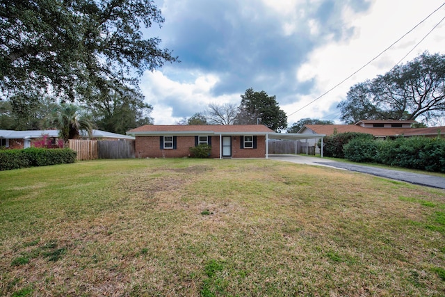 ranch-style house with driveway, an attached carport, a front yard, and fence