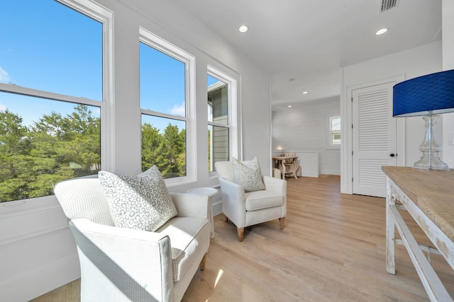 living area with recessed lighting, visible vents, and light wood finished floors