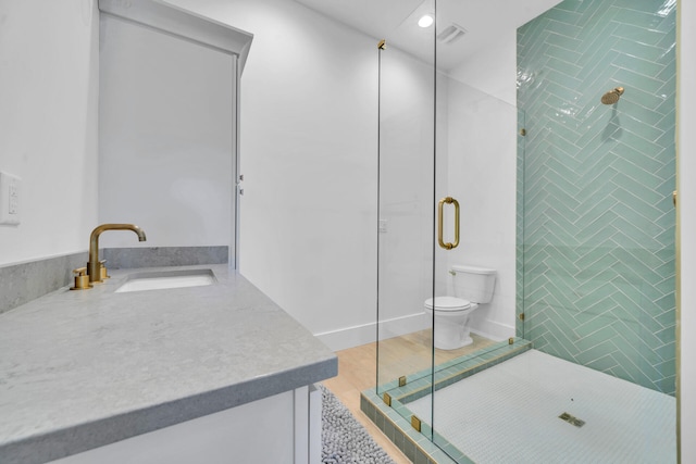 bathroom featuring toilet, visible vents, tiled shower, and vanity