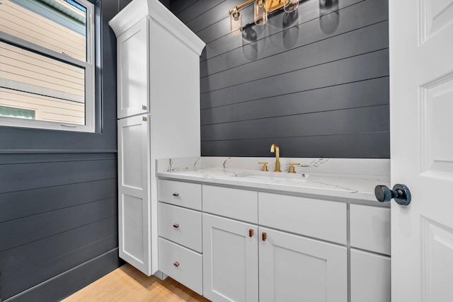 bathroom featuring wood walls and vanity