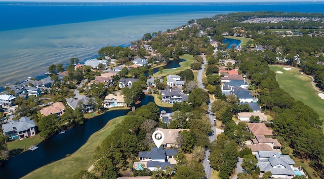 drone / aerial view featuring a residential view, view of golf course, and a water view