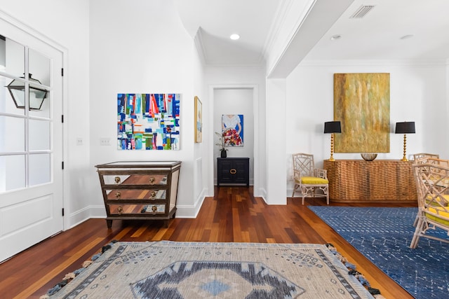 foyer entrance with crown molding, wood finished floors, and visible vents