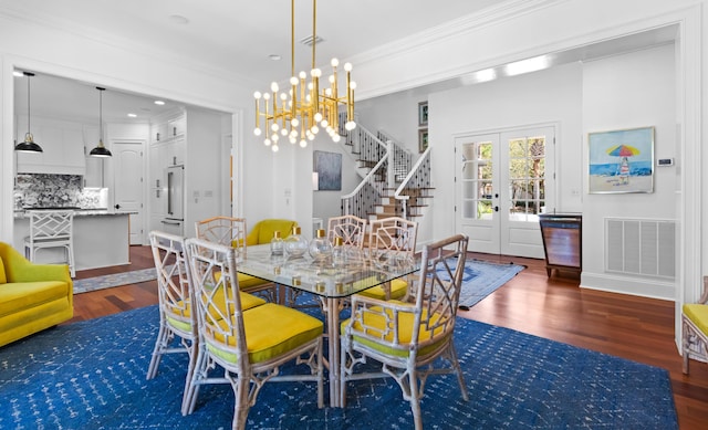 dining area featuring visible vents, ornamental molding, wood finished floors, french doors, and stairway