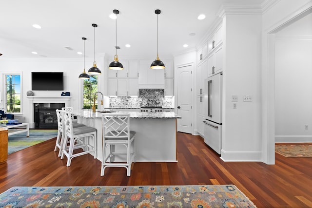 kitchen featuring white cabinetry, ornamental molding, tasteful backsplash, and a sink