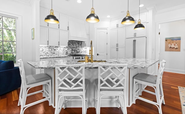 kitchen with dark wood-style floors, backsplash, white cabinetry, and built in fridge