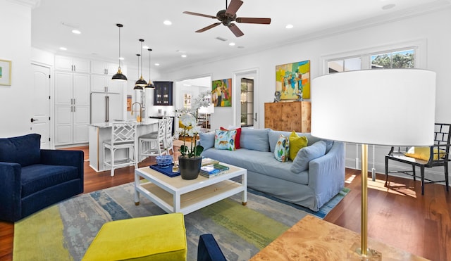 living room featuring recessed lighting, ornamental molding, dark wood-style flooring, and ceiling fan