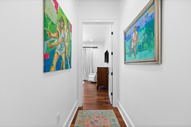 hall with baseboards, ornamental molding, and dark wood finished floors