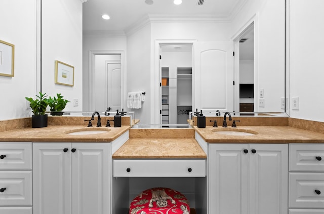 bathroom featuring vanity, a walk in closet, recessed lighting, and ornamental molding