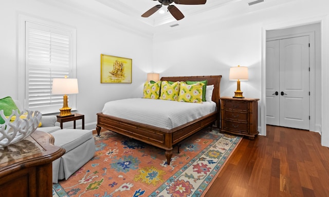 bedroom with visible vents, ornamental molding, wood finished floors, baseboards, and ceiling fan