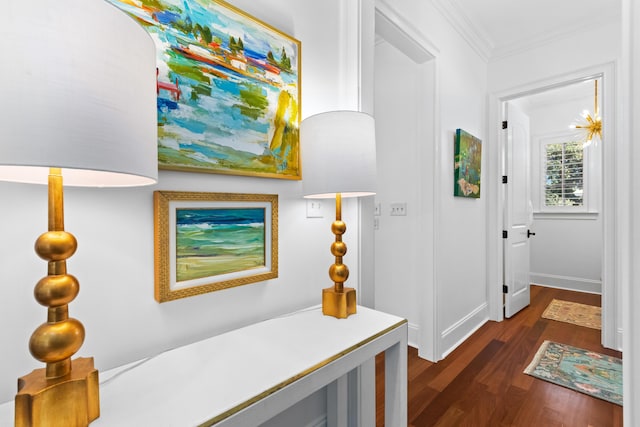 corridor featuring baseboards, ornamental molding, and dark wood-style flooring