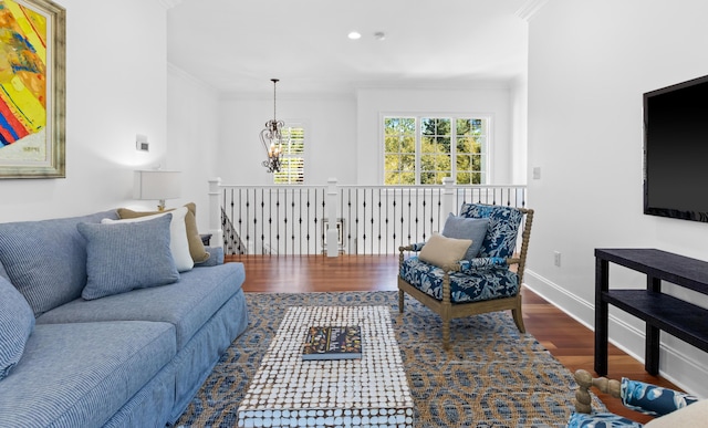 living room with wood finished floors, baseboards, an inviting chandelier, recessed lighting, and ornamental molding